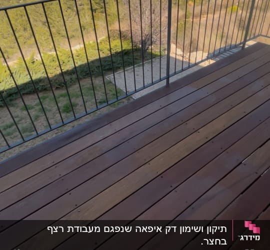 דק עץ עם מעקה מתכת בגינה